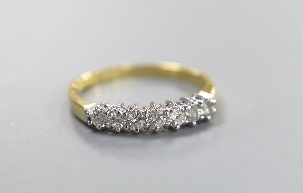 A modern 18ct gold and seven stone diamond set half hoop ring, size P/Q, gross weight 2.6 grams